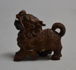JAPON
Netsuke en bois sculpté représentant un chien de Fô, signé
H.:...
