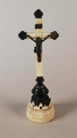 Crucifix en ivoire et bois noirci, reposant sur une base...