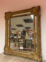 Miroir en bois doré à décor de coquilles aux écoinçons....