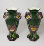 Une paire de vases en barbotine à décor floral sur...