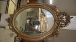 Un miroir ovale cadre en bois et stuc doré à...