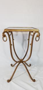 Une petite table de salon en métal doré et plateau...