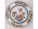 Une assiette en porcelaine - à décor floral polychrome et...
