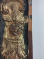Un bas-relief en bois sculpté à décor de visage et...