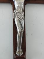 Un crucifix en métal argenté sur croix en bois et...