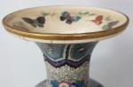 Un vase en émaux cloisonnés sur céramique à décor floral...