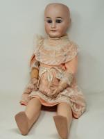 Une poupée à tête de porcelaine, H : 66 cm,...