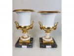 Une paire de vases Médicis en porcelaine blanche et dorée...