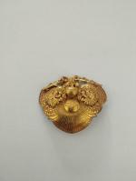 Broche polylobée en métal doré  à décor extrême-oriental stylisé...