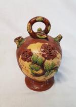 Une chevrette en poterie polychrome à décor de roses et...