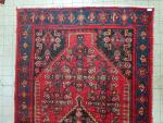 Un tapis en laine à fond rouge - Iran -...