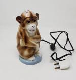 Une veilleuse en porcelaine représentant un singe assis - Epoque...