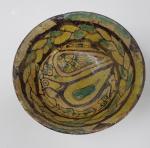 Un bol en céramique vernissée à décor d'oiseau stylisé polychrome...