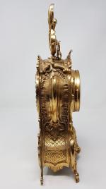 Une pendule en bronze doré - à décor de rinceaux...