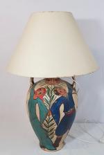 Une lampe en poterie à décor polychrome de personnages et...