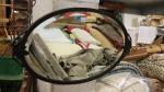 Un miroir ovale en fer forgé, glace biseautée, H. 38...