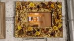 Un miroir cuivré, cadre à décor d'inscrustation de fleurs séchées,...