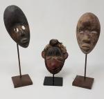 Trois masques navettes en bois patiné sur leur présentoir -...