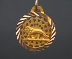 Pendentif circulaire en or jaune, à décor d'un lion sur...
