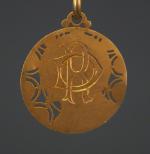 Médaille religieuse en or jaune, à décor ajouré de fleur...