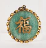 Chine, XXe siècle, 
Pendentif en jadeite cerclé de cuivre doré...