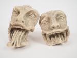 Deux têtes de monstres grimacants en pierre sculptée, on joint...