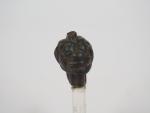 Amulette en bronze représentant la tête du démon assyrien Pazuzu....