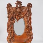 Miroir XIXème en bois sculpté à décor d'amours dans une...