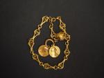 Bracelet en or à décor de lambrequins agrémenté d'une pendeloque...